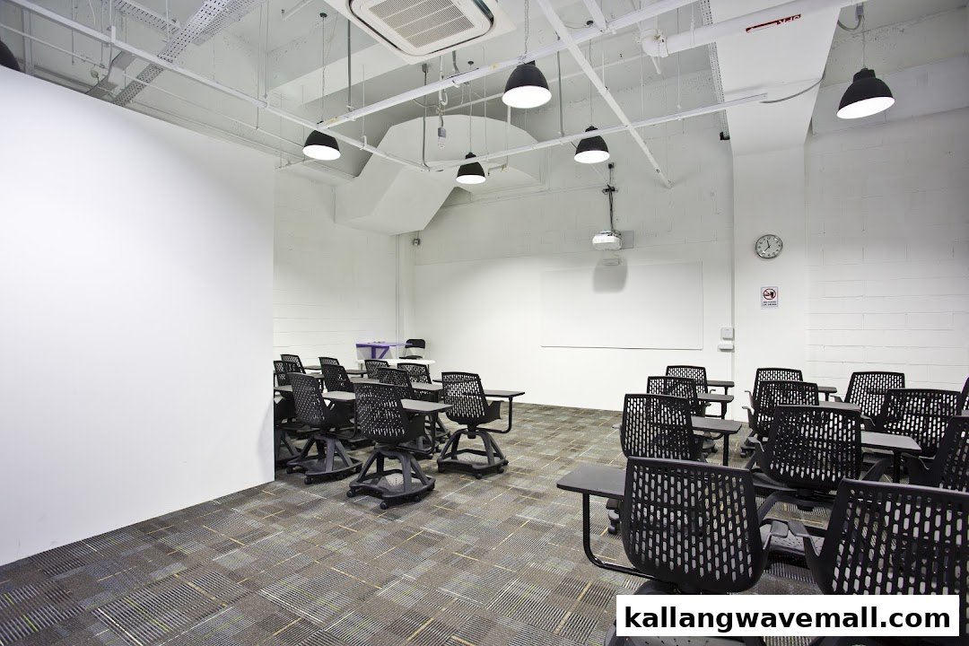 An empty, modern classroom with black chairs and desks, ready for training sessions.