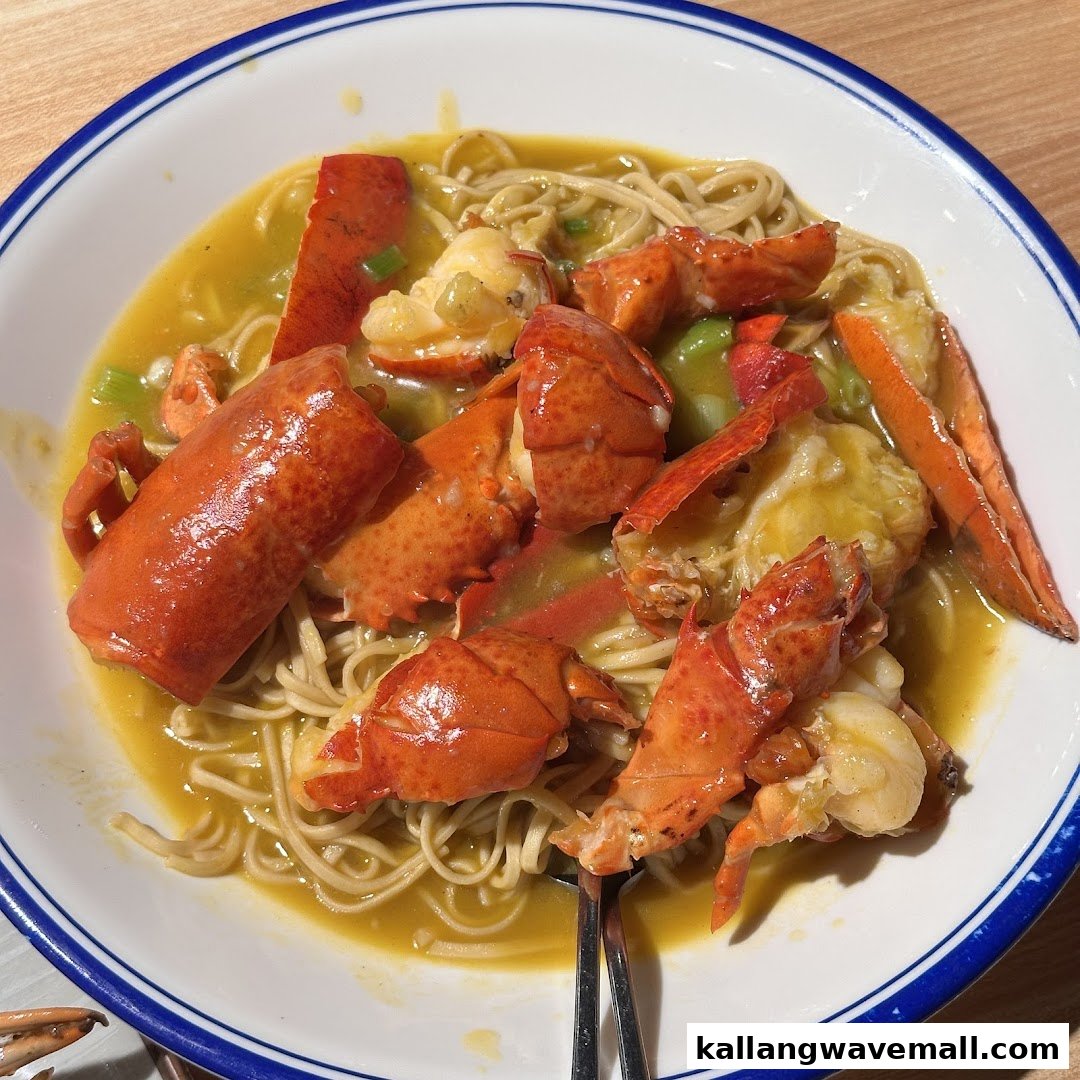 A vibrant dish featuring succulent lobster pieces served over noodles in a rich, golden sauce.