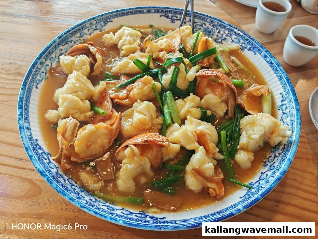 A vibrant dish featuring stir-fried seafood, possibly lobster or large shrimp, with green onions in a savory sauce.