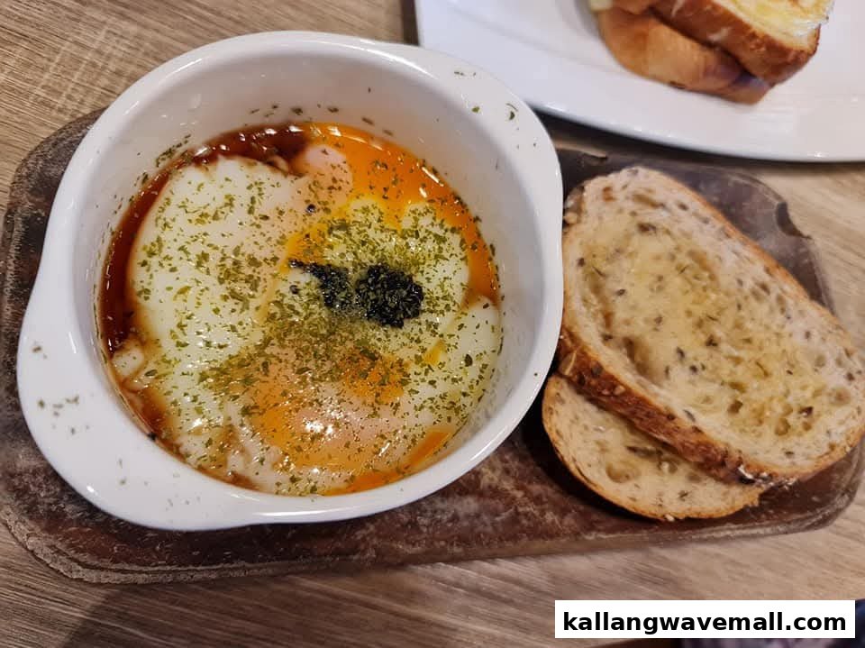 A close-up of baked eggs with herbs and two slices of toasted bread on a wooden board.