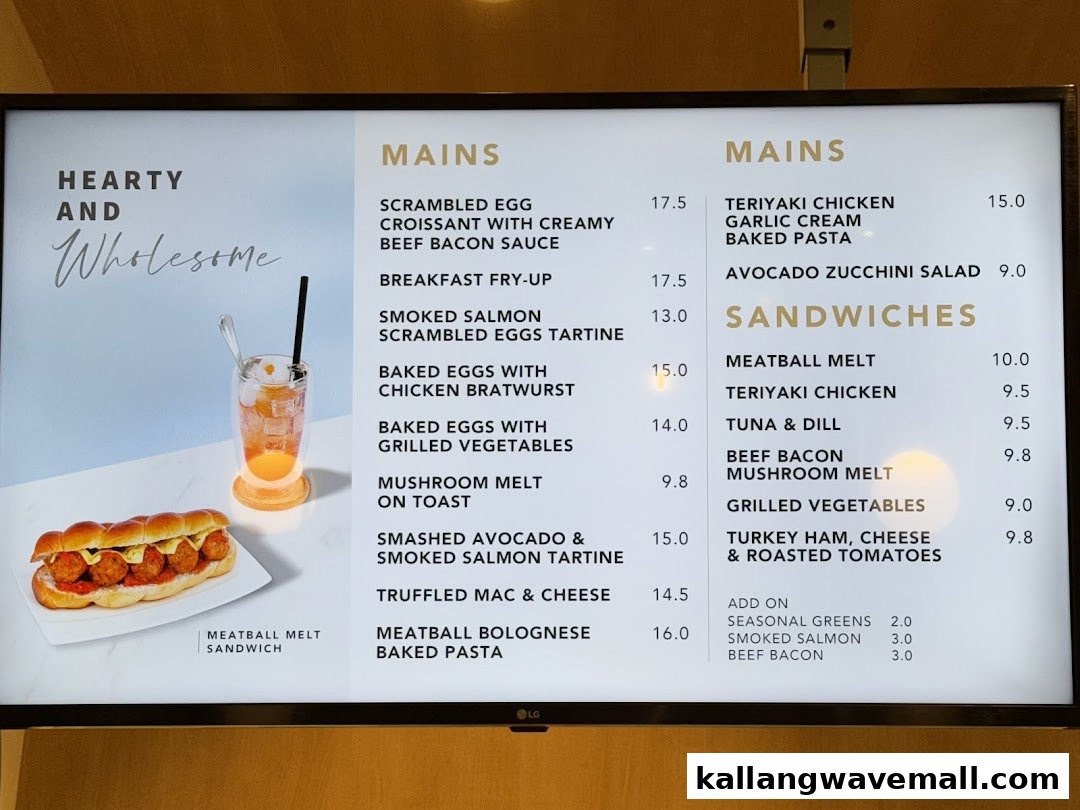 A digital menu board displaying a variety of hearty mains, sandwiches, and add-ons with prices.