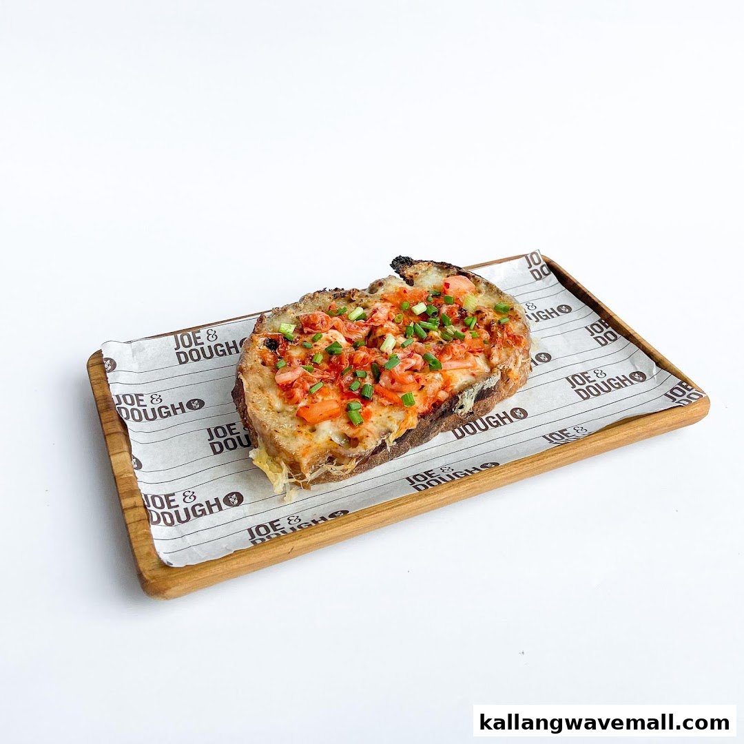 A delicious savory toast topped with cheese, red sauce, and chives on a wooden tray.