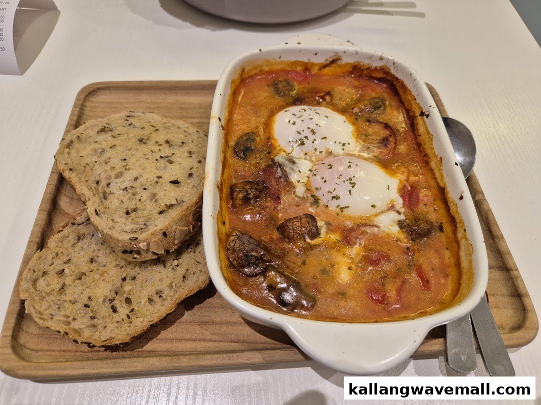 A delicious baked egg dish with tomato sauce, mushrooms, and whole-grain bread on a wooden tray.