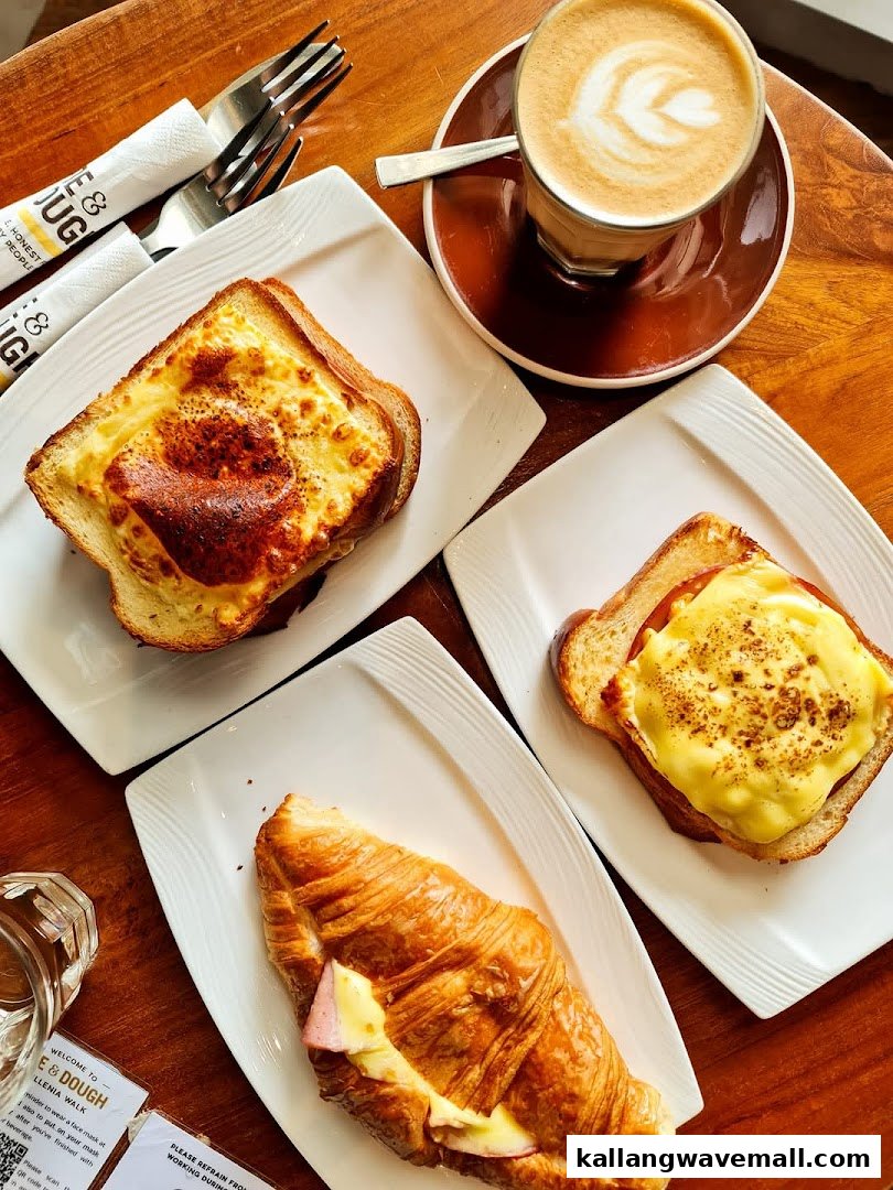 A top-down view of delicious breakfast items including toasts, a croissant, and a latte on a wooden table.