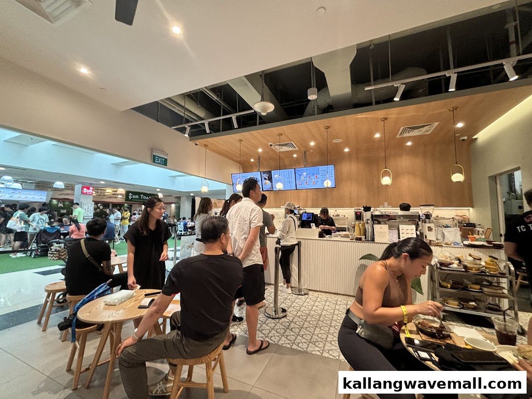 Customers are ordering and dining inside Joe Dough, a bustling cafe with a modern counter and seating area.