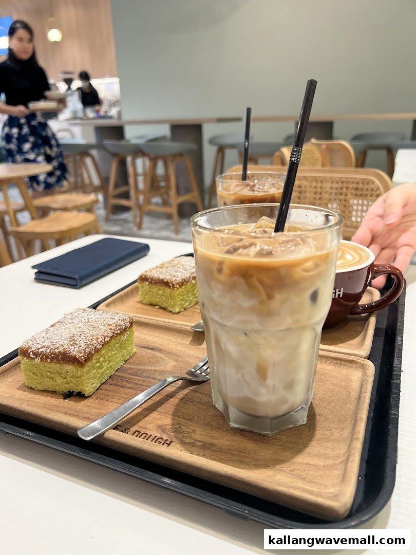 A tray with iced coffees and green cakes on a table in a modern cafe setting.