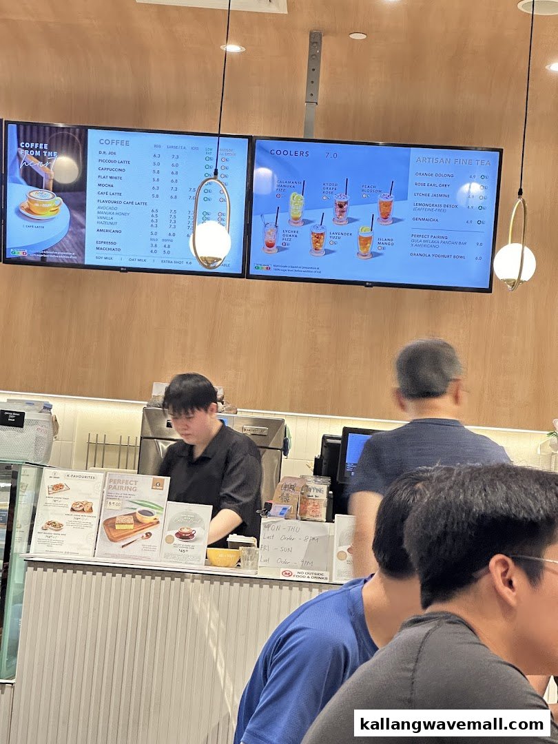 Interior view of Joe Dough cafe showing digital menus, a service counter, and customers.