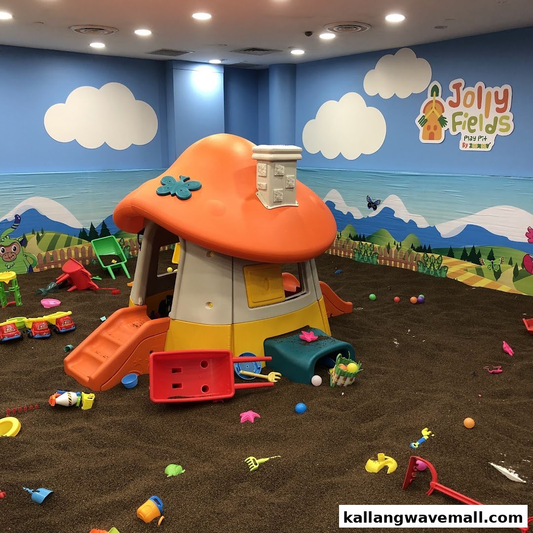 An indoor play pit with a mushroom house, various toys, and a colorful mural.