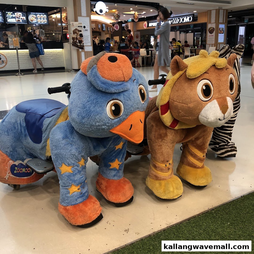 Two large, colorful plush animal rides, a blue duck and a brown lion, are displayed in a shopping mall.