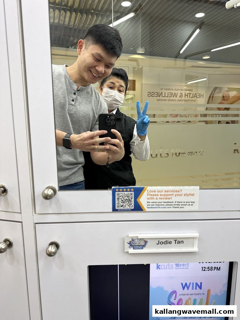 A customer and stylist smiling for a selfie in a kcuts salon, showcasing friendly service.