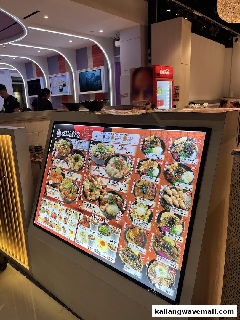 A brightly lit digital menu board showcasing various Japanese rice bowls and add-ons at Kei Kaisendon.