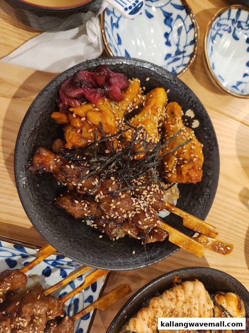A close-up of a Japanese donburi bowl featuring various grilled skewers, pickled vegetables, and seaweed.