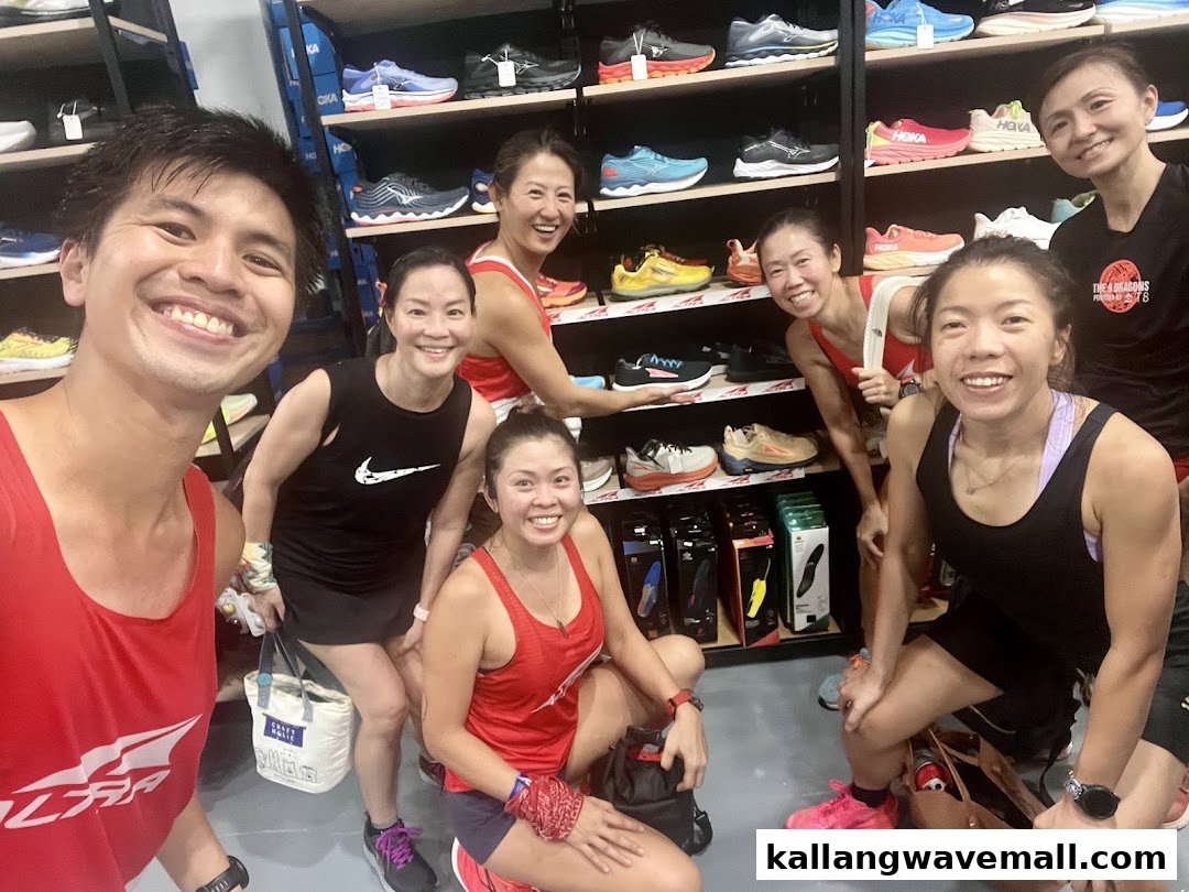 A group of smiling people posing inside Key Power Sports, surrounded by athletic shoes.