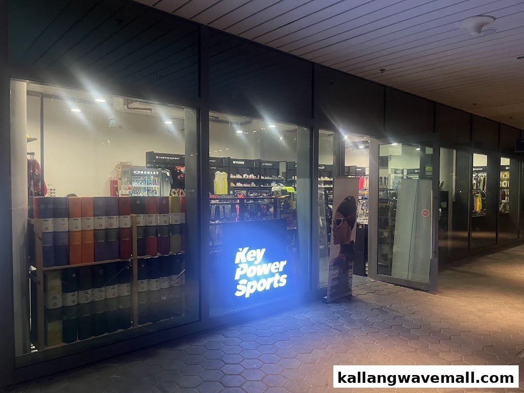 The illuminated storefront of Key Power Sports, showcasing sports apparel and gear at night.