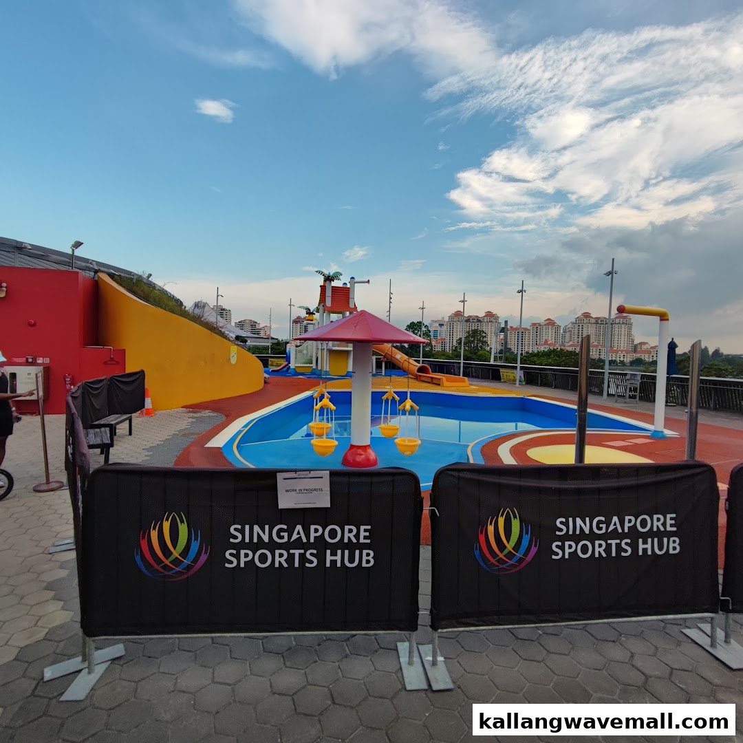 A vibrant outdoor water play area with slides and splash features, currently undergoing work.