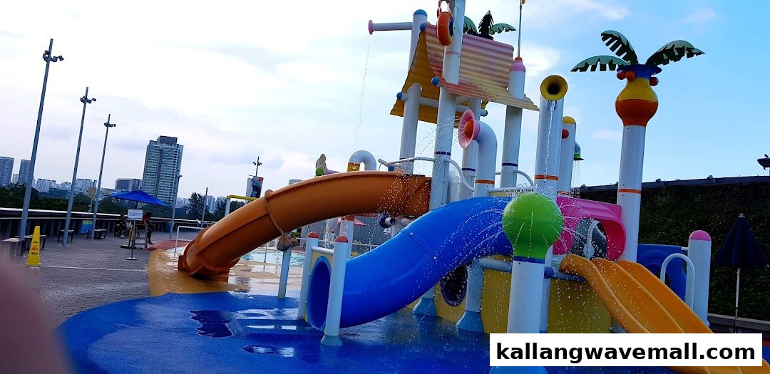 A vibrant outdoor water play area with colorful slides and interactive water features under a clear sky.