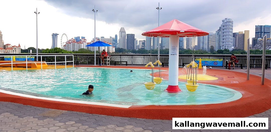 A vibrant outdoor water play area for kids with a city skyline backdrop.