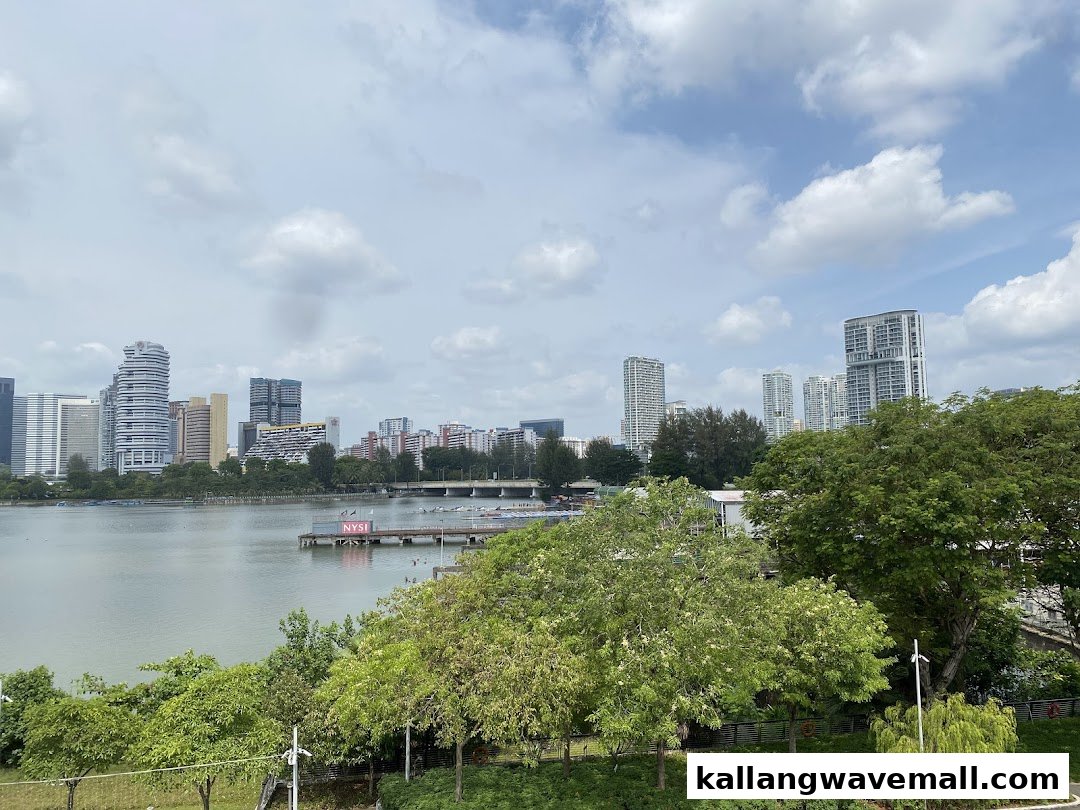 A scenic view of a city skyline across a lake with green trees under a cloudy sky.