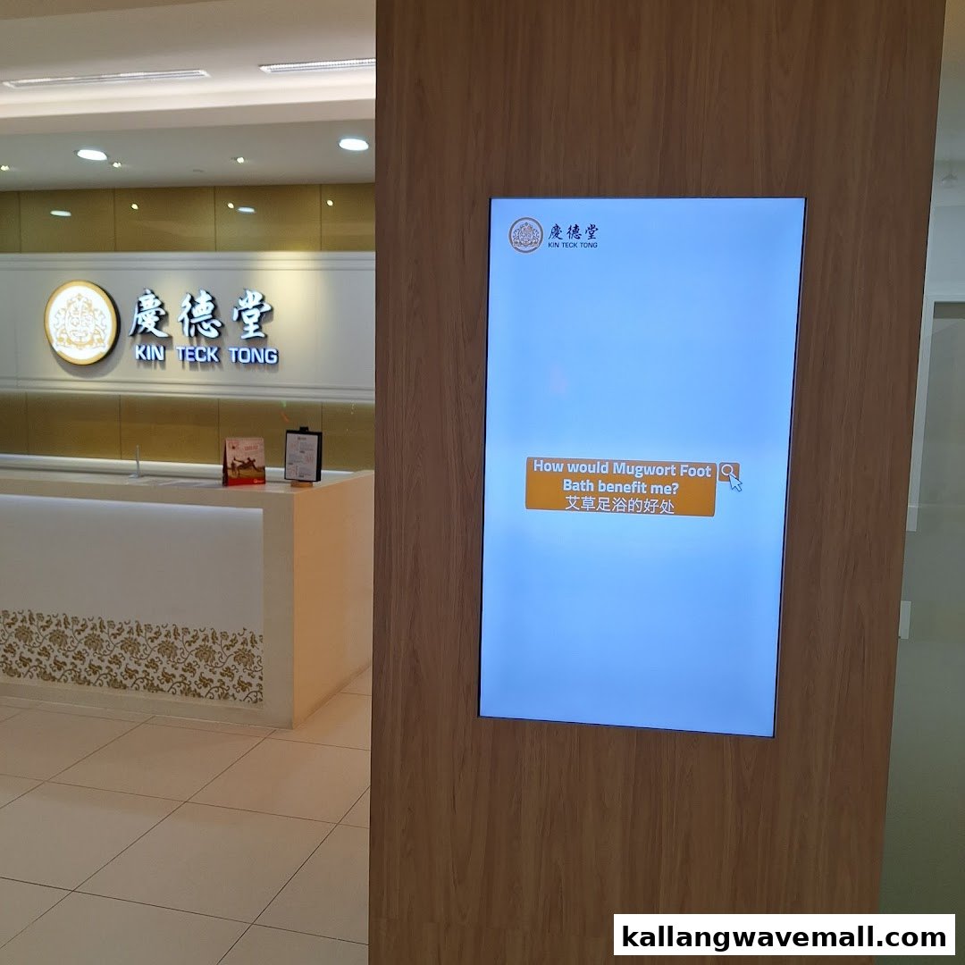 The image shows the modern reception area of Kin Teck Tong TCM Clinic with a digital information display.