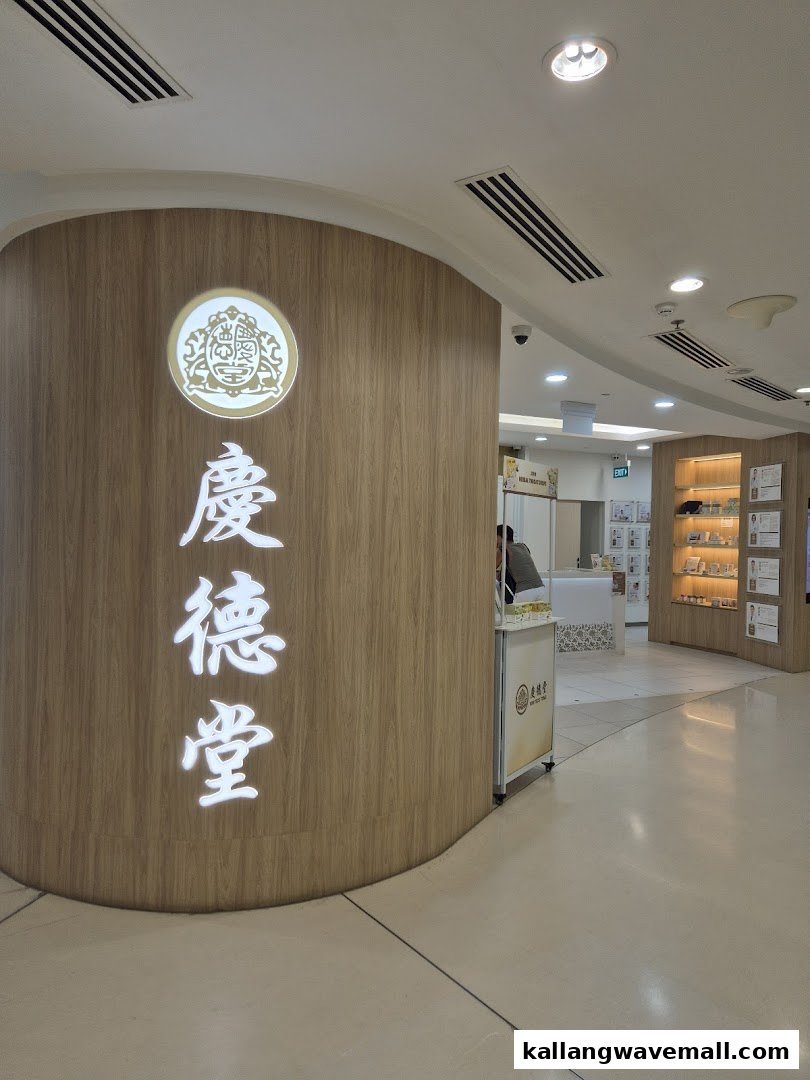 The image displays the curved wooden entrance of Kin Teck Tong TCM Clinic, featuring its illuminated Chinese name and logo.