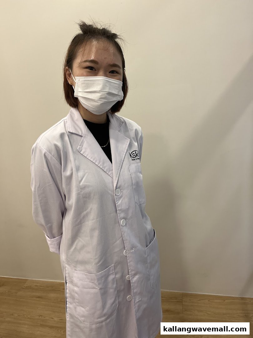 A friendly Kskin staff member in a white lab coat and face mask, ready to assist.