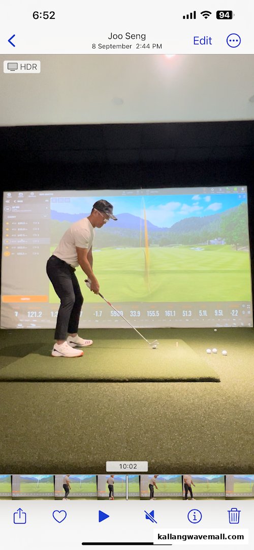 A golfer practices their swing on an advanced indoor golf simulator at Lip Golf.