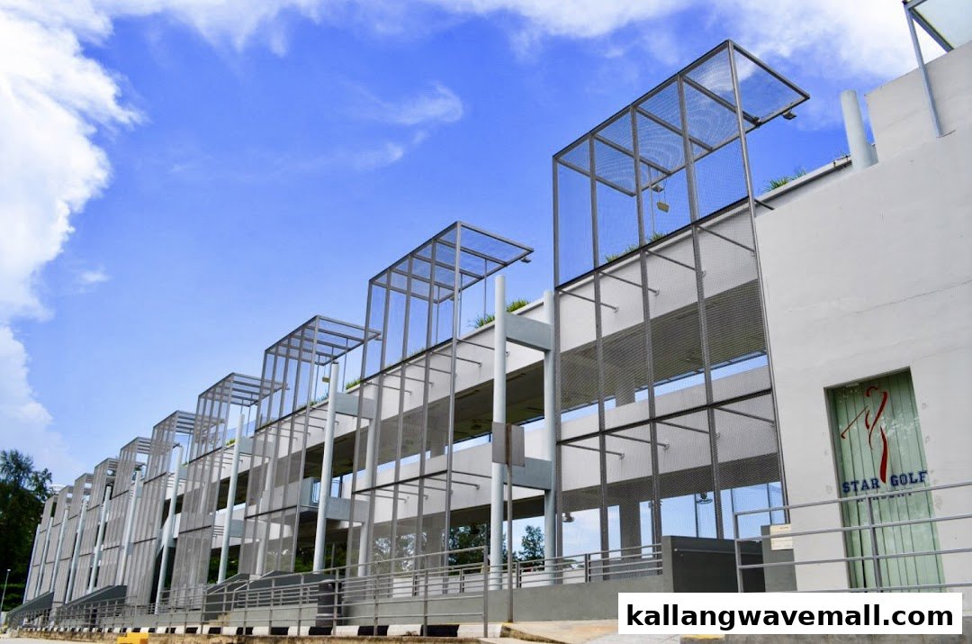 Exterior view of a multi-level golf driving range building under a bright blue sky.