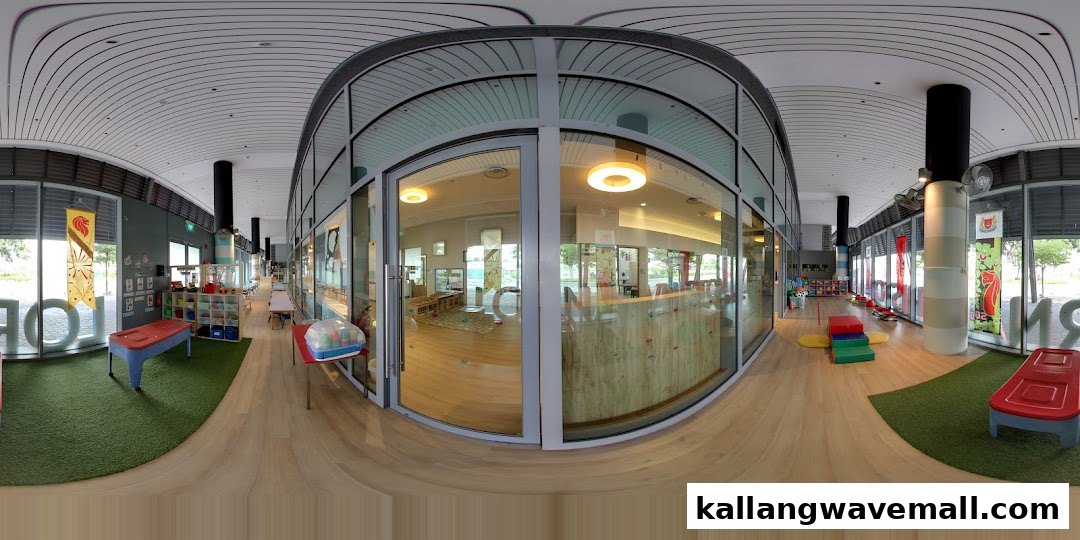 A panoramic view of the bright, spacious interior of a preschool with play areas and classrooms.