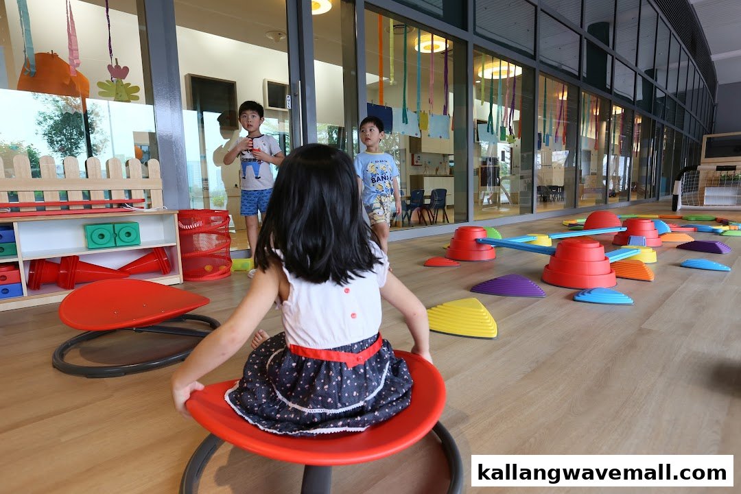Children engage in playful learning activities within a bright, spacious preschool environment.