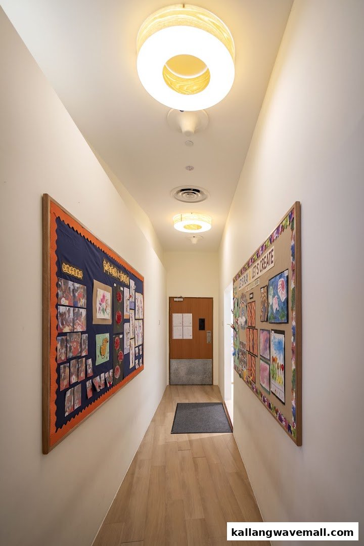 A bright hallway in a preschool, adorned with colorful children's artwork on bulletin boards.