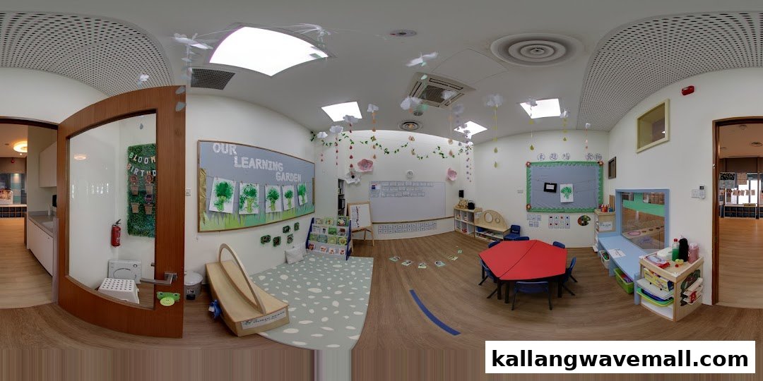A bright and inviting preschool classroom with learning displays, small tables, and play areas.