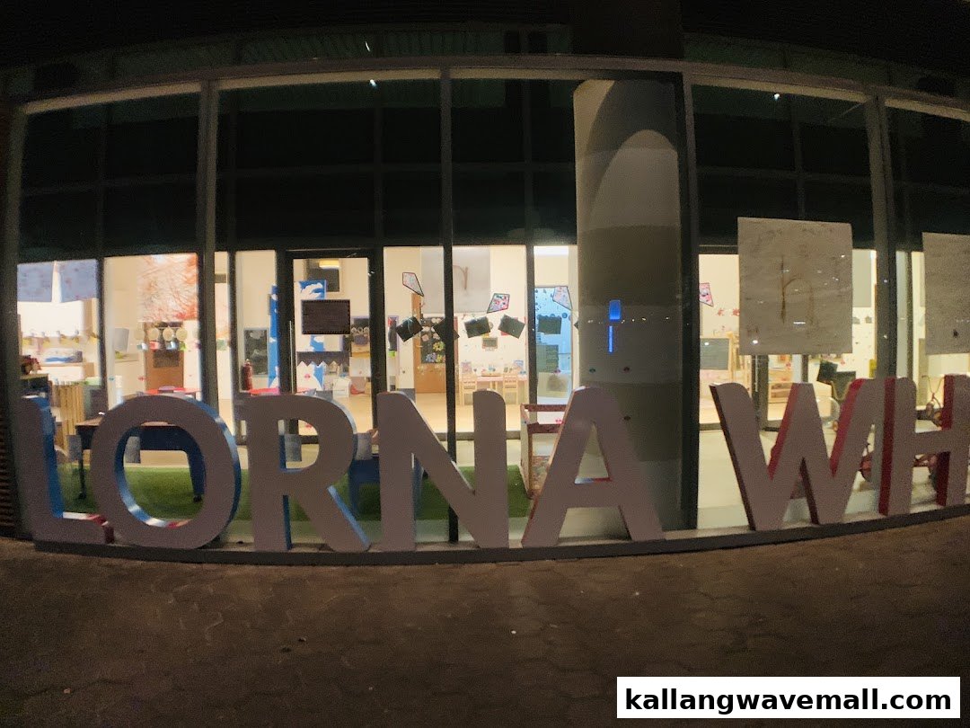 The illuminated entrance of Lorna Whiston Preschool at night, featuring large outdoor signage.