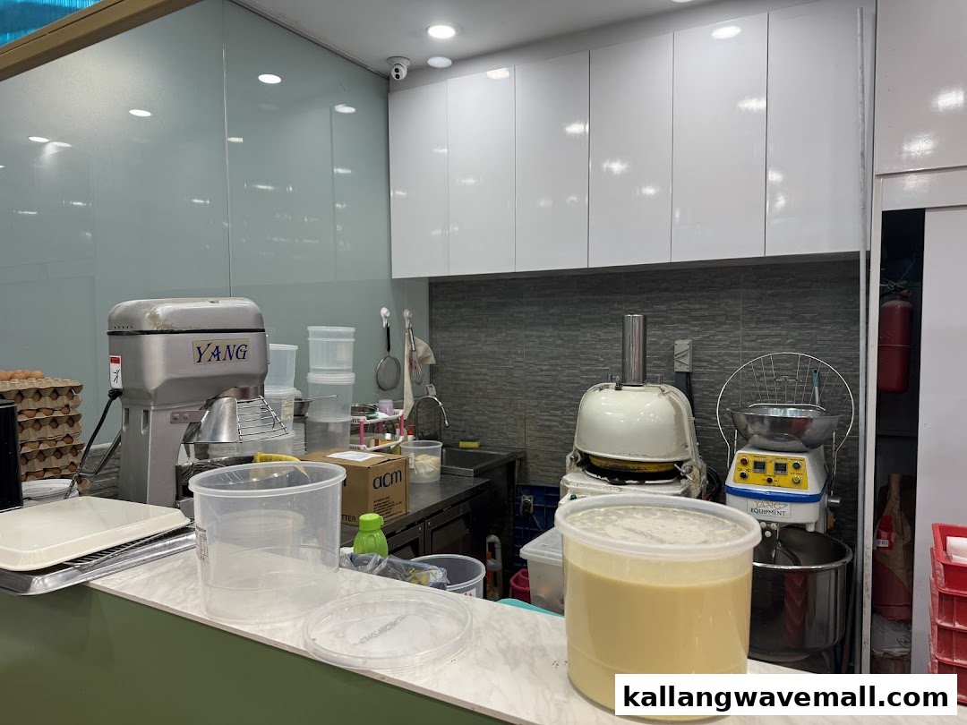 A clean commercial kitchen counter with baking equipment, including mixers and ingredients, suggesting fresh preparation.