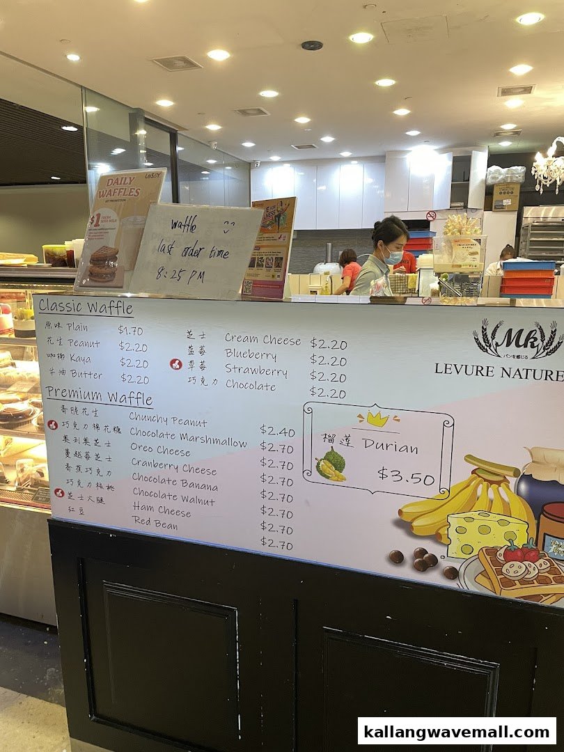 A menu board displaying various classic and premium waffle flavors with their prices at MK Levure Naturelle.