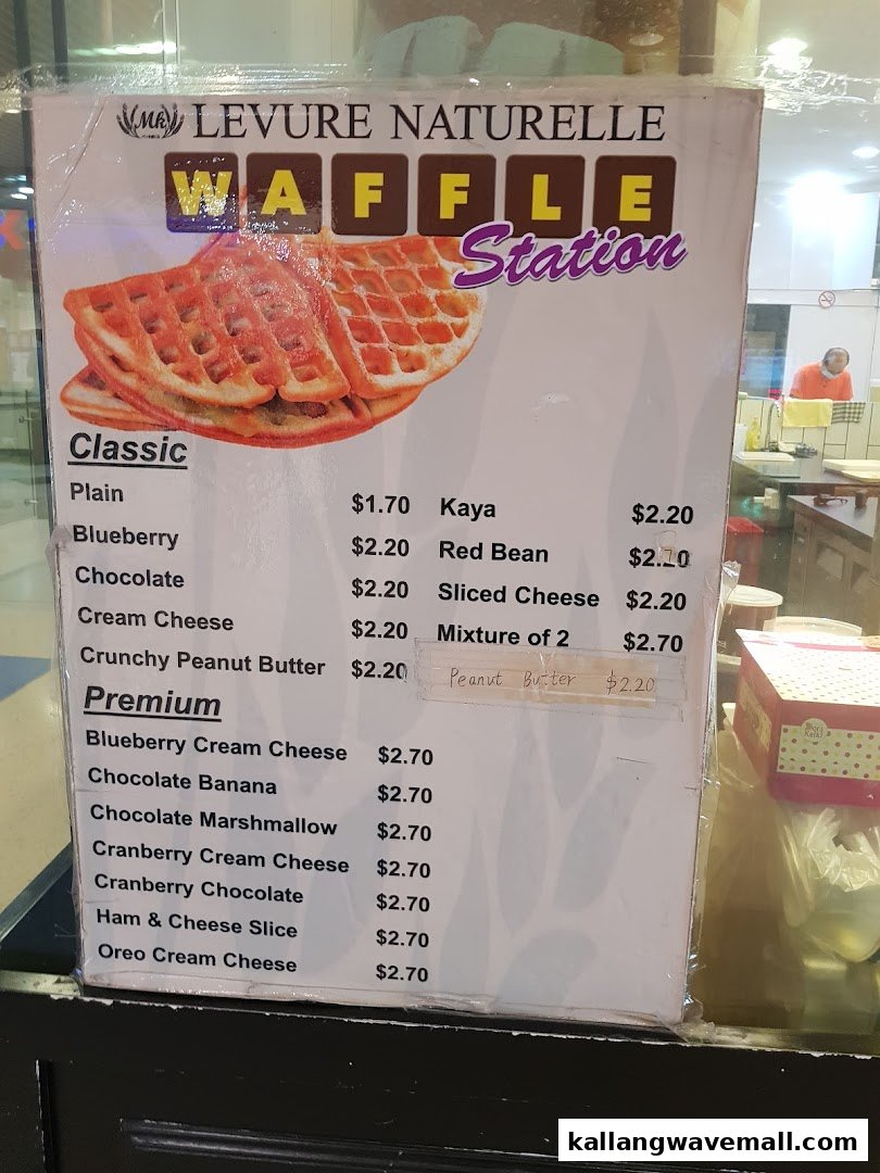 A menu board displaying various waffle flavors and prices from MK Levure Naturelle Waffle Station.