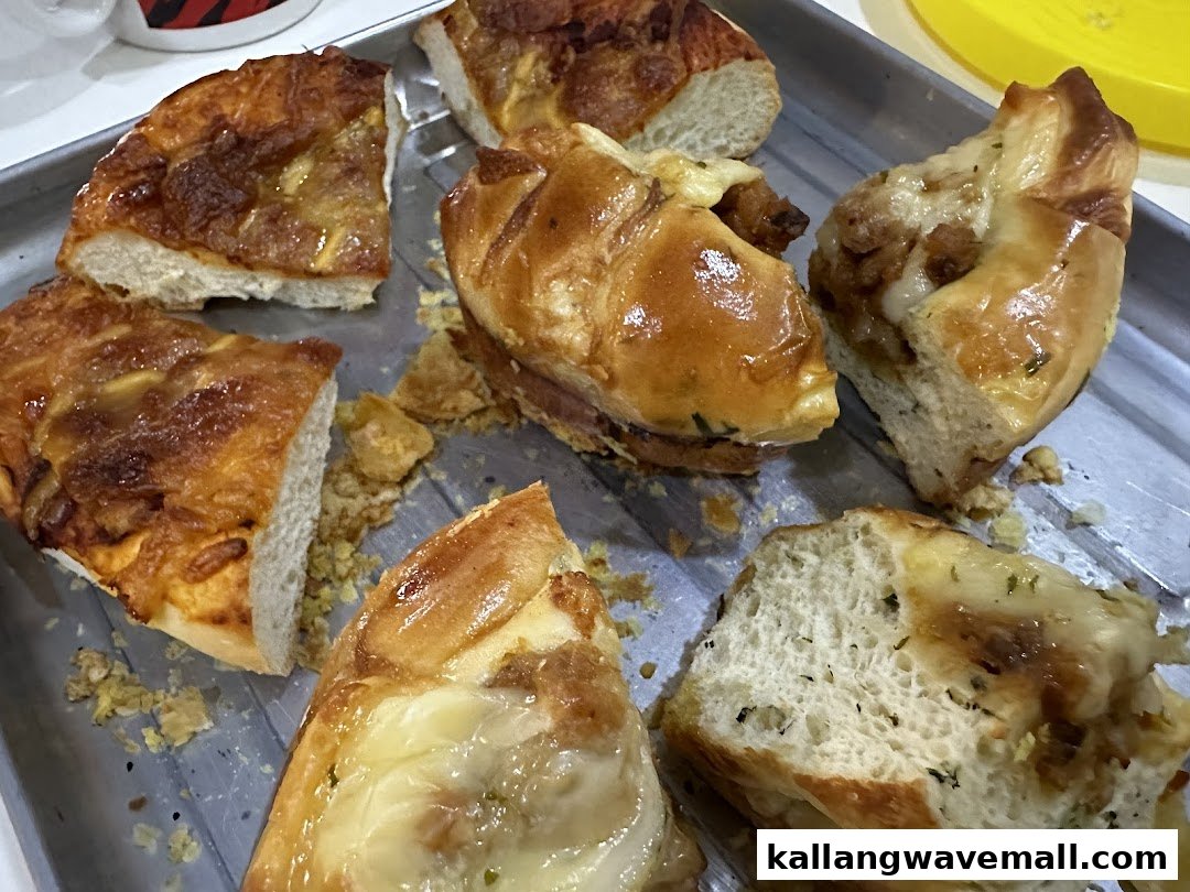 A metal tray filled with various savory baked goods, including bread slices and stuffed pastries.