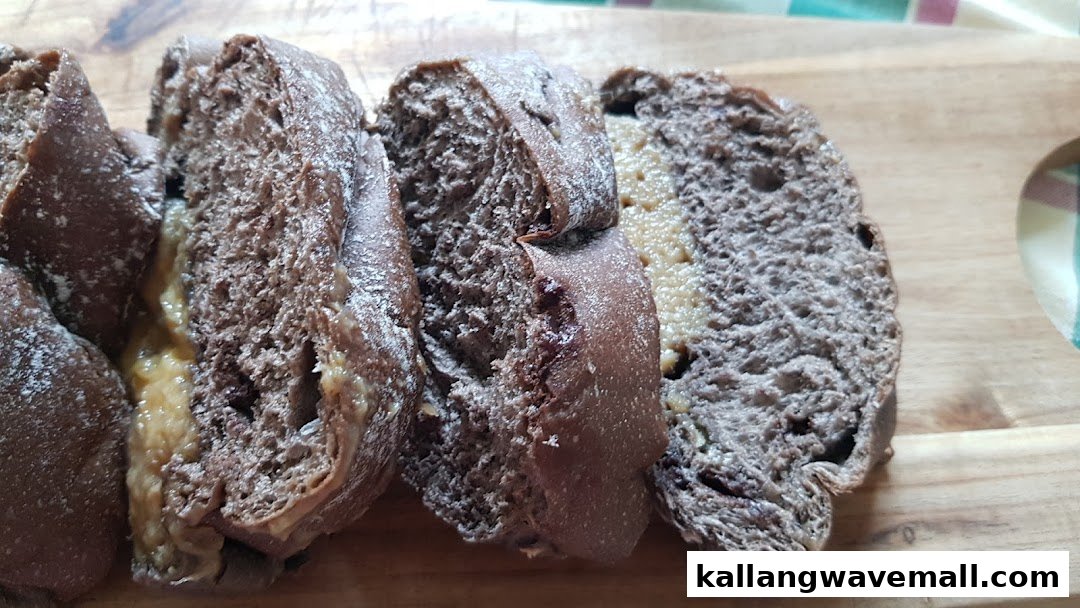 Close-up of several slices of dark bread with a creamy filling, resting on a wooden cutting board.