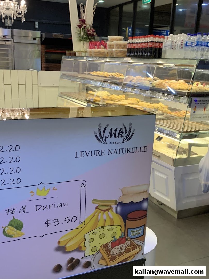 A partial view of a bakery's display case with pastries and a promotional sign showing prices.