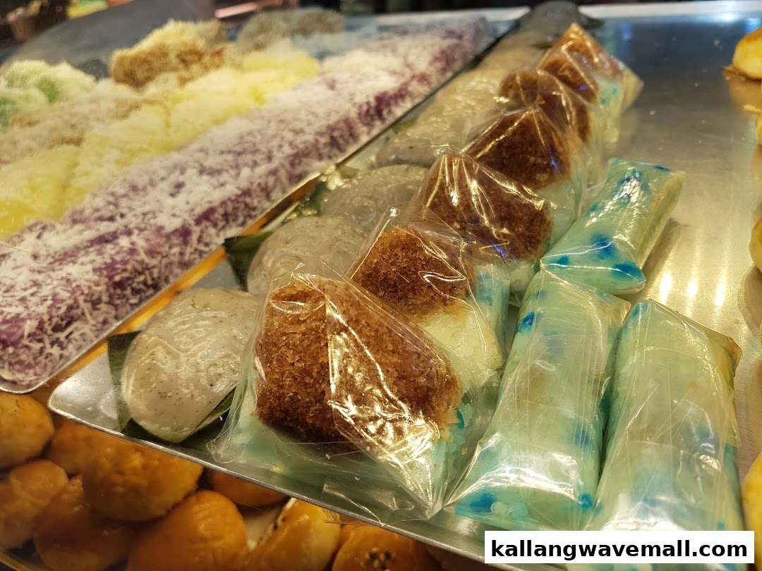 A vibrant display of various traditional pastries and sweet treats, some individually wrapped, in a bakery setting.
