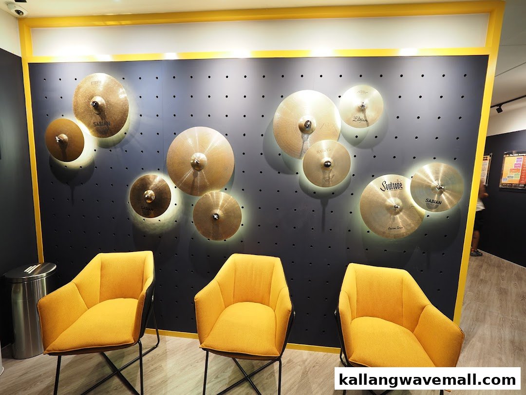 An interior shot of My Drum School featuring a cymbal-decorated wall and three yellow chairs.