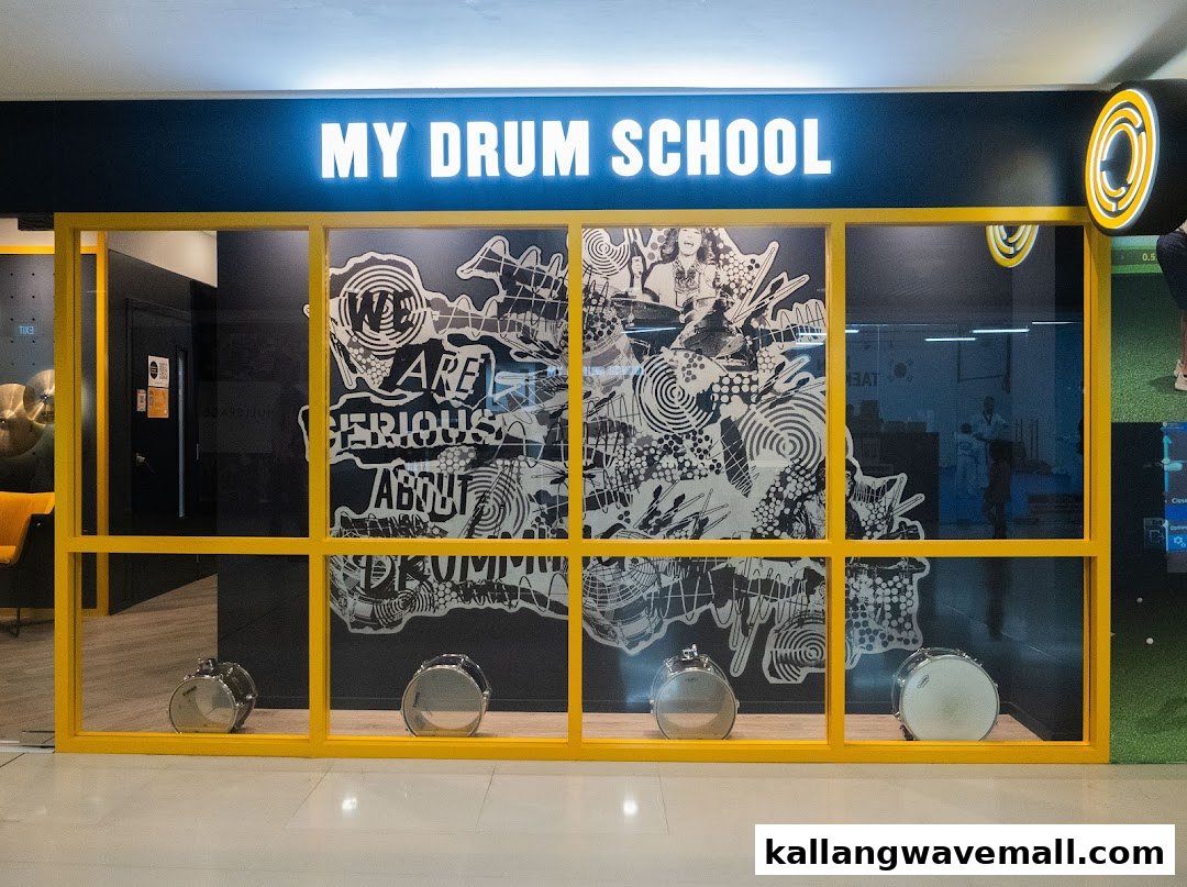 The vibrant yellow and black shop front of My Drum School, featuring drums and artistic window decals.