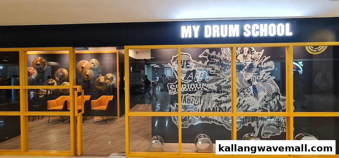 The vibrant yellow-framed entrance of My Drum School, showcasing cymbals and drums, inviting aspiring musicians.