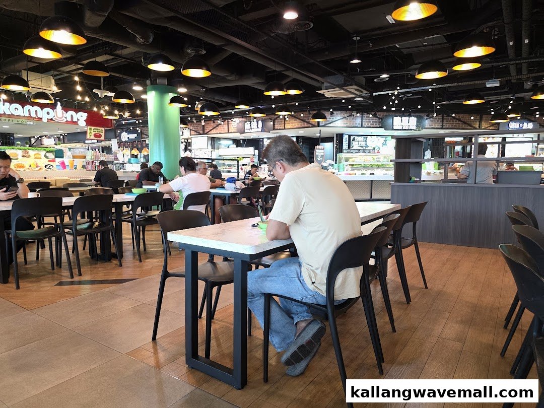 Diners enjoying meals in a bustling food court with various food stalls and ample seating.