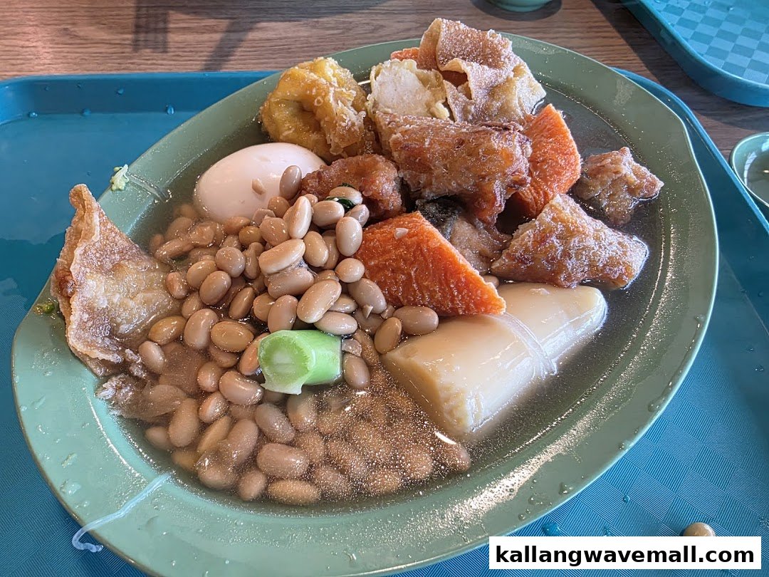 A close-up of a traditional Asian dish featuring various ingredients like beans, egg, and fried items in a savory broth.