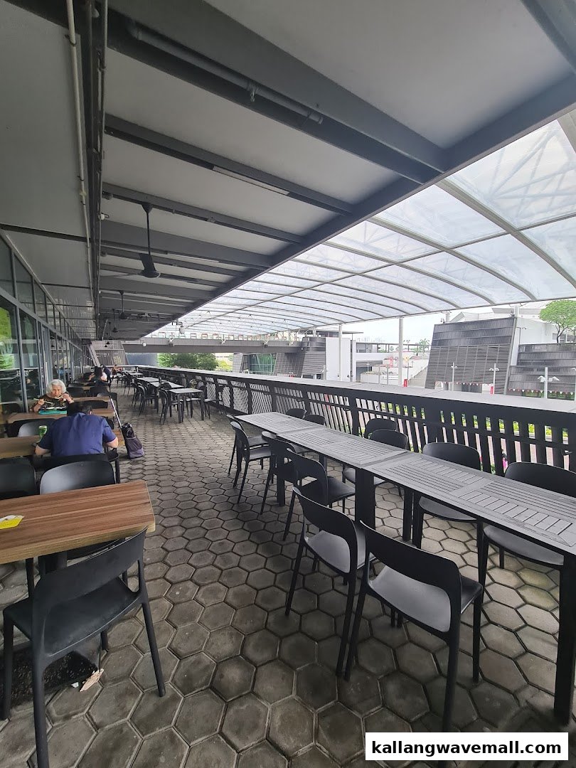 A spacious outdoor dining area with numerous tables and chairs under a covered patio at My Kampung.
