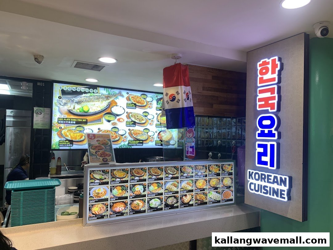 A vibrant food stall counter showcasing a large digital menu board with various Korean dishes and prices.