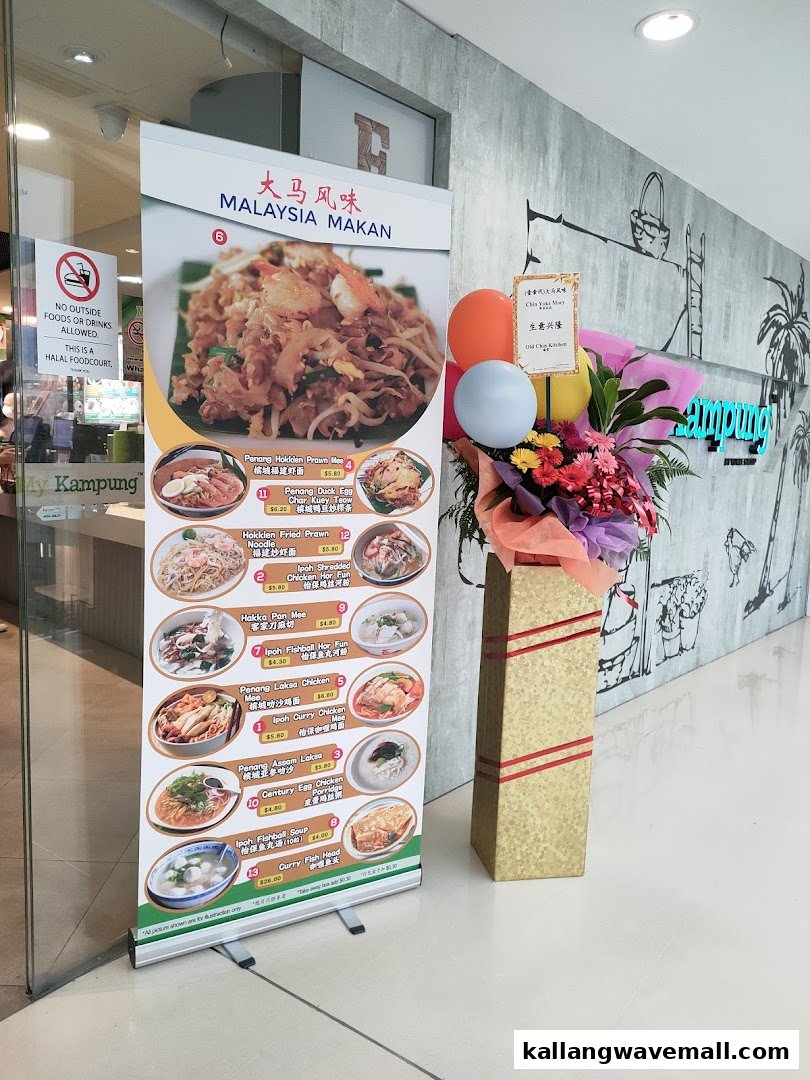 A vibrant menu banner showcasing various Malaysian dishes at the entrance of My Kampung food court.