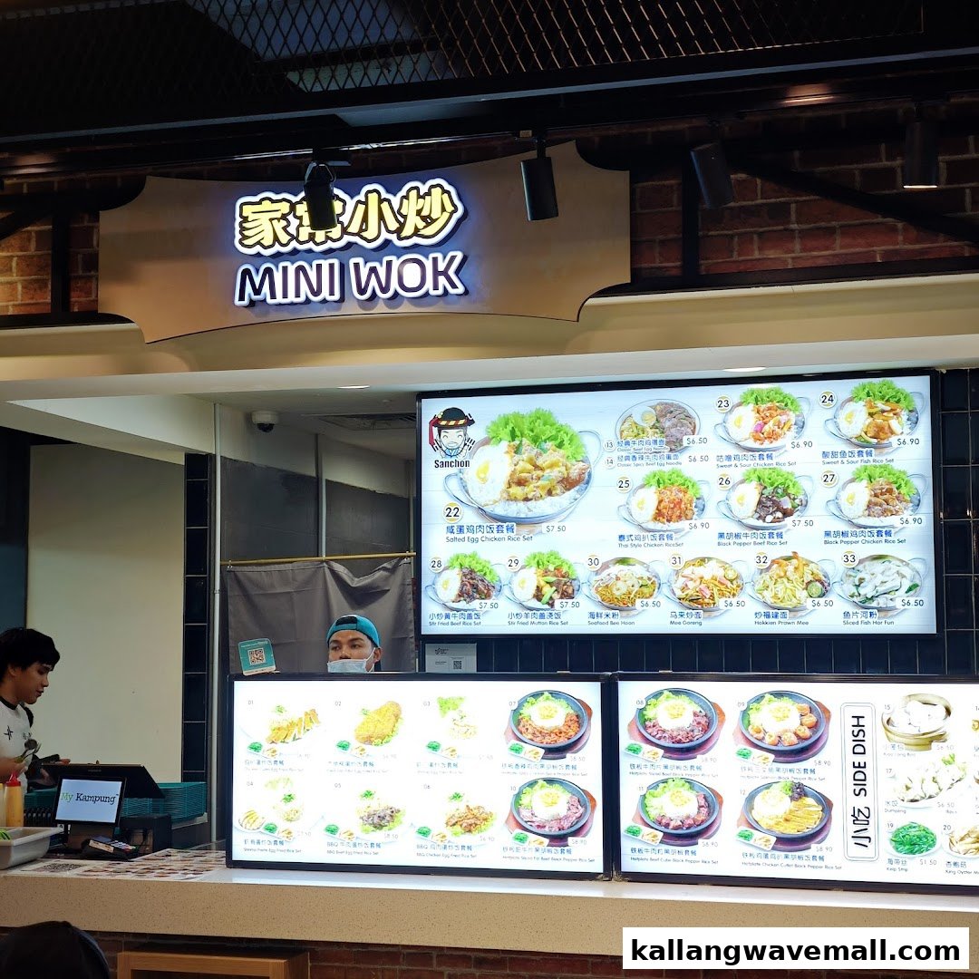 A vibrant food stall named Mini Wok, part of My Kampung, showcasing extensive digital menu boards with various Asian dishes.