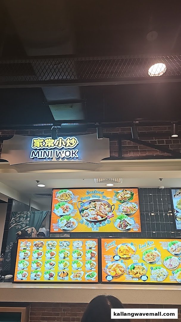 Digital menu boards displaying various Asian stir-fry, curry, and fried rice dishes at Mini Wok.
