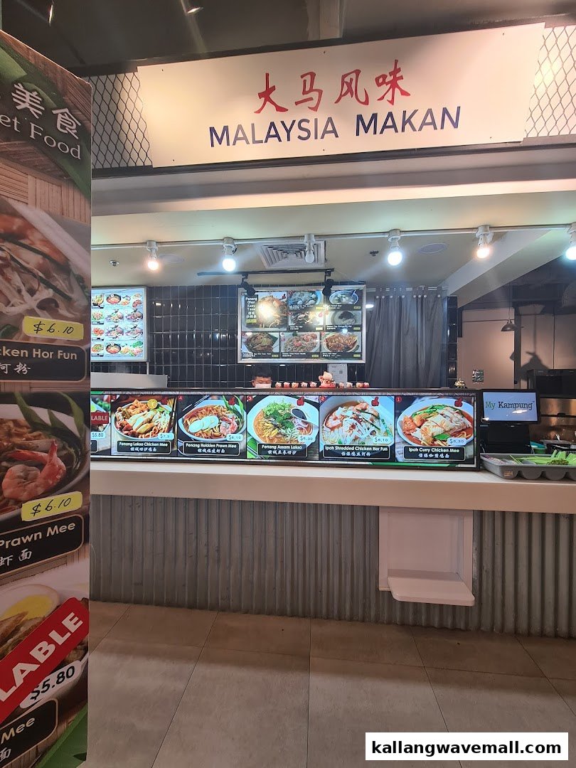 A vibrant food stall named 'Malaysia Makan' showcasing various Malaysian noodle dishes and prices.